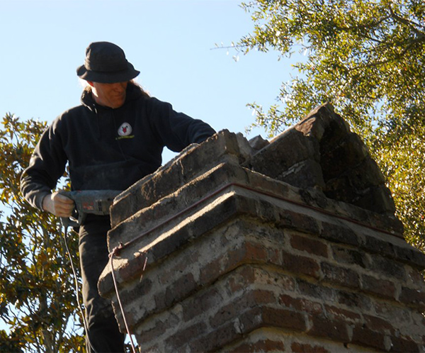 mason working on brick chimney